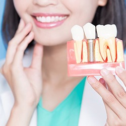 dentist holding model of dental implants in Newburyport