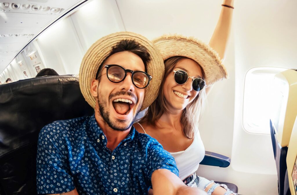 Smiling couple taking selfie on airplane