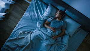 Top view of young man sleeping in bed